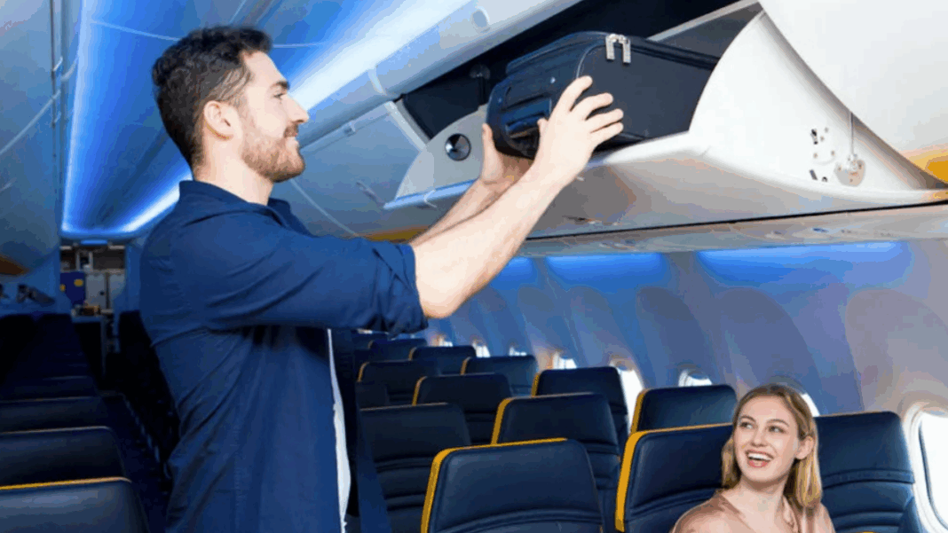 Homem guardando mala de mão no bagageiro do avião