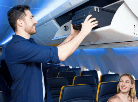 Homem guardando mala de mão no bagageiro do avião