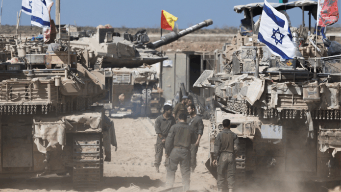 Soldados israelenses ao lado de tanques perto da fronteira entre Israel e Gaza