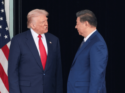 Donald Trump e Xi Jinping se olham ao lado da bandeira dos EUA