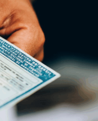 Mão de uma pessoa negra segurando uma CNH