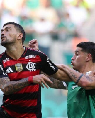 O jogador Emiliano Martínez, do Palmeiras, disputa bola com Arrascaeta do Flamengo