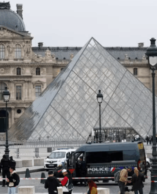 Entrada principal do Museu do Louvre, em Paris, com carro de polícia parado na frente