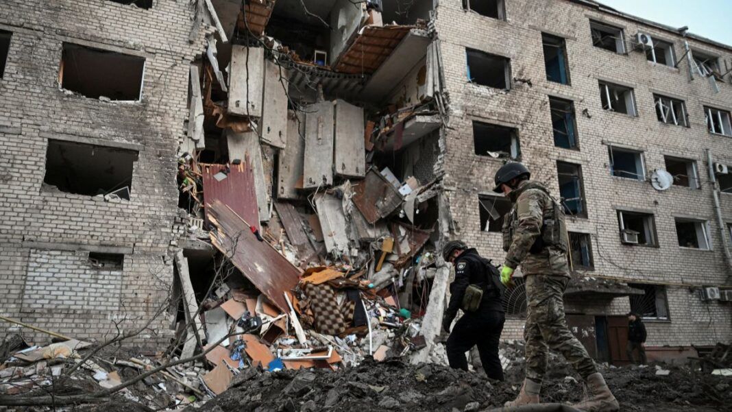 Soldados ucranianos inspecionam destroços de um prédio vitimado pelo bombardeio russo