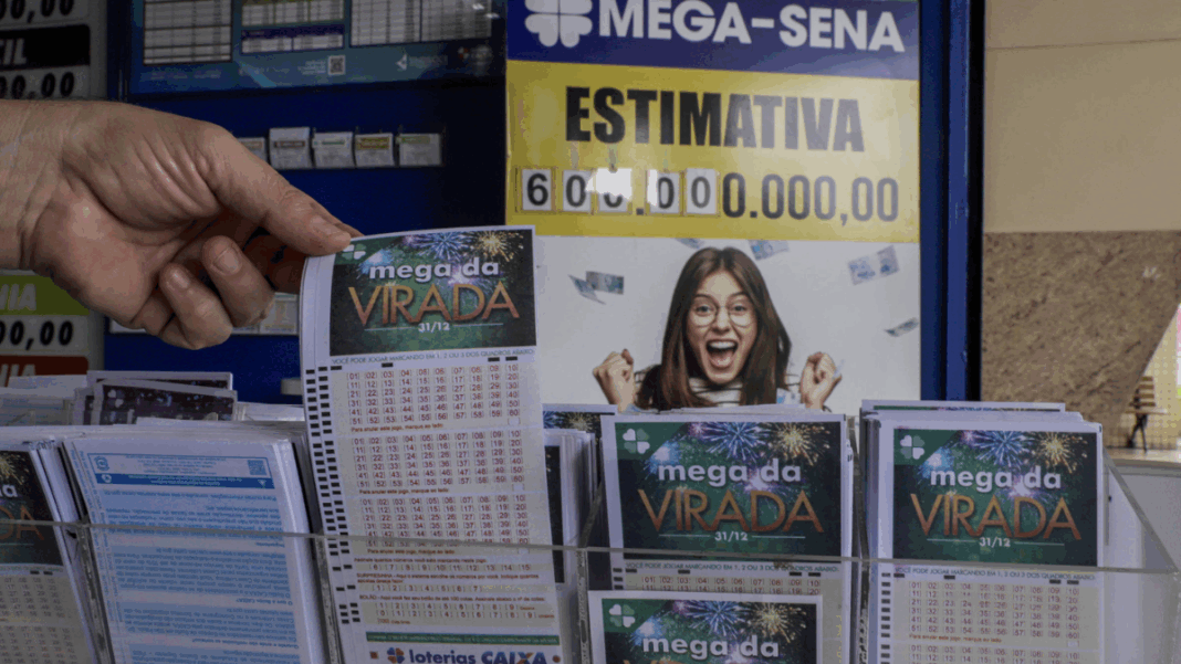 Pessoa segura um volante da “Mega da Virada” em uma casa lotérica. Ao fundo, um cartaz da Mega-Sena exibe a estimativa de prêmio de 600 milhões de reais e a imagem de uma mulher sorridente comemorando.