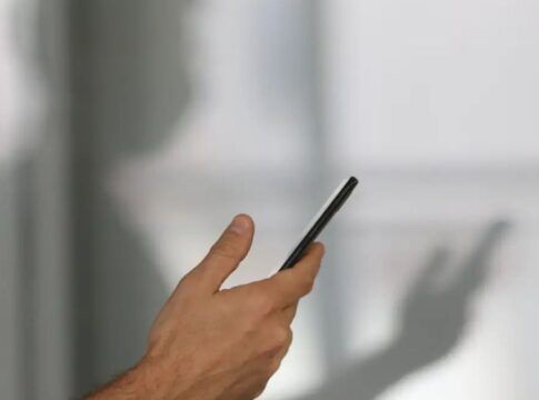 Imagem colorida de pessoa segurando o celular