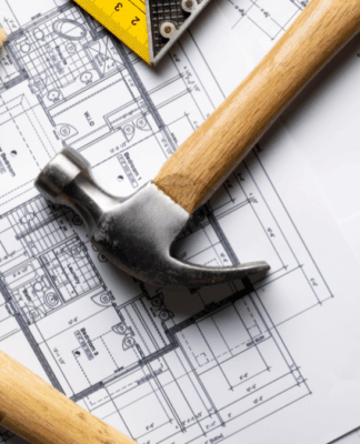Ferramentas de construção sobre plantas arquitetônicas. Imagem ilustrativa de reformas e projetos habitacionais.