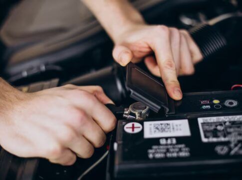 Homem arrumando a bateria do carro