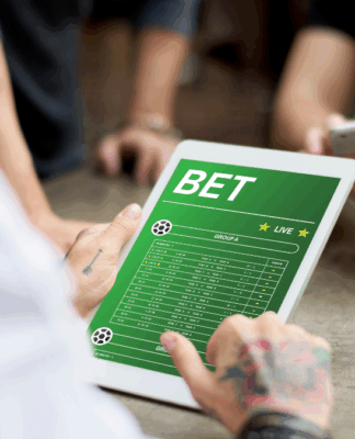 Close na mão de uma pessoa navegando em uma página de bet, em um tablete