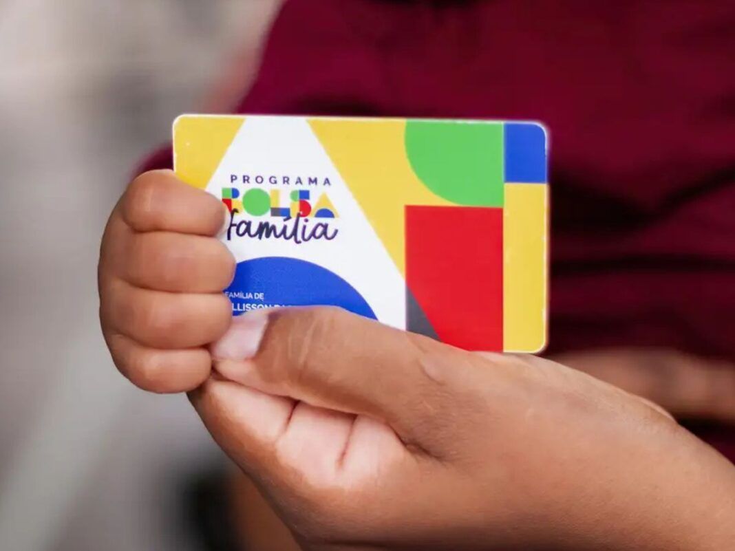 Pessoa segurando o cartão do Bolsa Família