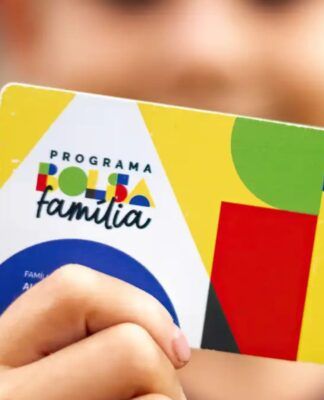 A imagem mostra uma criança segurando o cartão do Bolsa Família