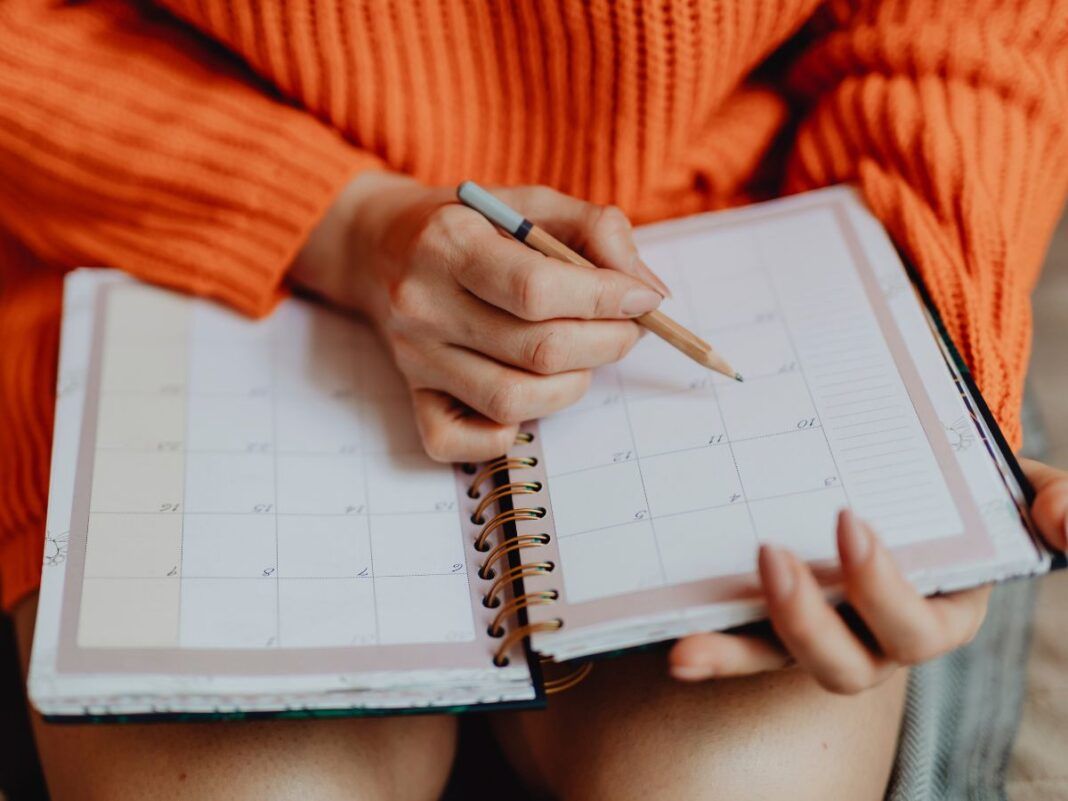 Mulher fazendo anotações na agenda