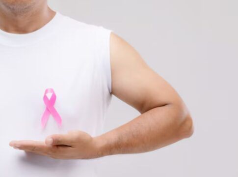 Homem segurando uma fitinho de outubro rosa