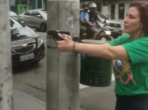 Parlamentar Carla Zambelli (PL-SP), em 2022, empunhando e apontando uma arma na rua