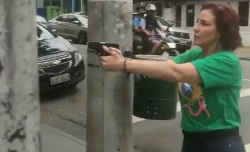 Parlamentar Carla Zambelli (PL-SP), em 2022, empunhando e apontando uma arma na rua