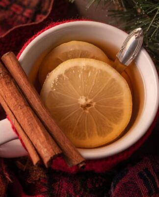 Xícara com chá de canela com rodelas de limão