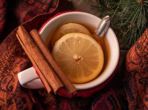 Xícara com chá de canela com rodelas de limão