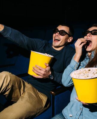 Homem e mulher comendo pipoca no cinema