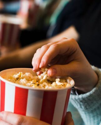 Pessoa comendo pipoca no cinema