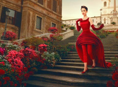 Protagonista Lilly Collins de Emily Em Paris , descendo uma escada de vestido vermelho
