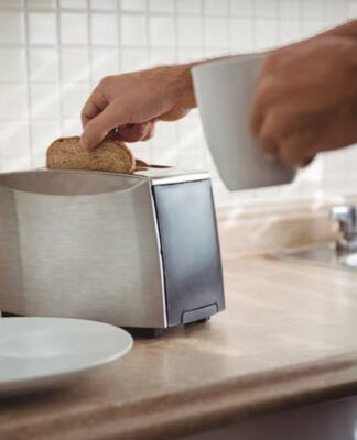 Homem tirando pão da torradeira