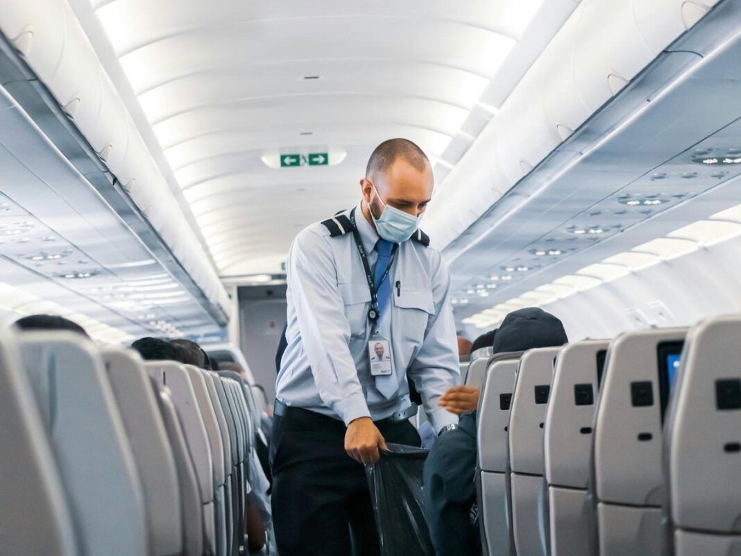 Imagem colorida de comissário de bordo homem em um avião
