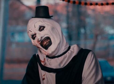 Homem vestido de palhaço com maquiagem branca e batom preto.