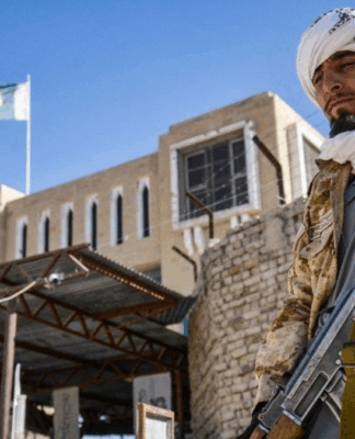 Integrante armado da segurança do Talibã monta guarda diante do portão fechado na passagem de fronteira entre o Afeganistão e o Paquistão