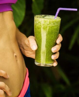 Barriga malhada e copo de suco vere detox
