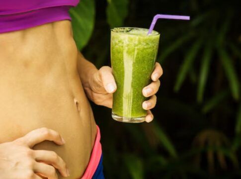 Barriga malhada e copo de suco vere detox