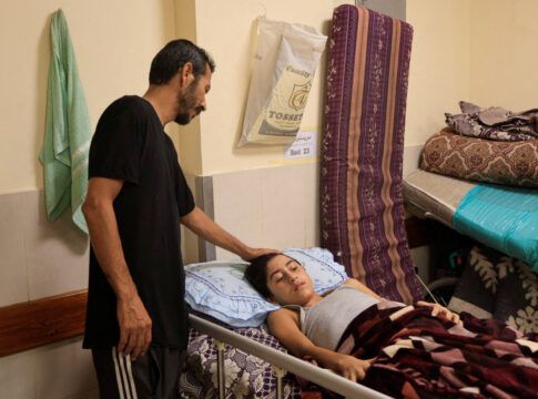 Pai cuidando do filho ferido em Gaza