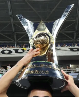 Troféu do Brasileirão Série A 2024 sendo segurado por mãos, sobre a cabeça de um atleta