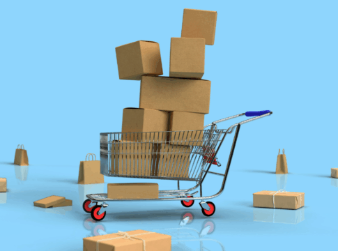 Carrinho de compras cheio de caixas de papelão empilhadas, cercado por mais pacotes espalhados no chão brilhante, sobre um fundo azul claro que remete ao ambiente de compras online ou promoções.