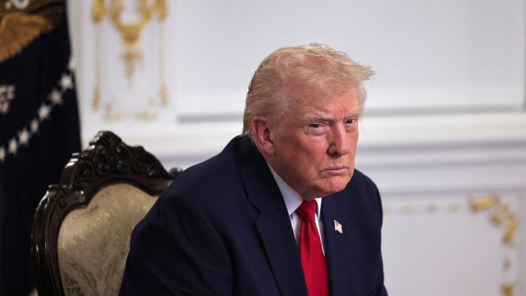 Homem branco com idade elevada de terno e gravata vermelha