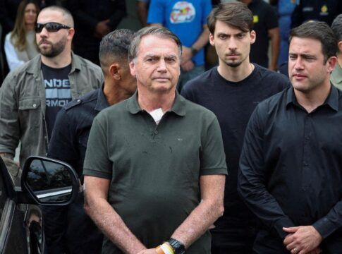 Jair Bolsonaro aparece ao lado de viatura da polícia, ao lado de filhos e apoiadores
