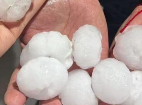 Imagem mostra pedras grandes de granizo em duas mãos