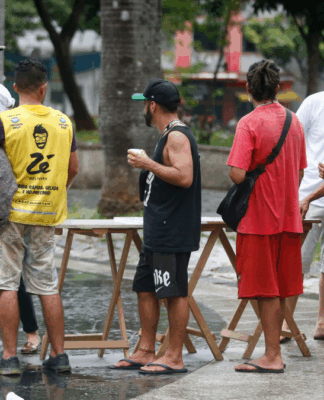 Moradores de rua recebem comida na Sé em SP.