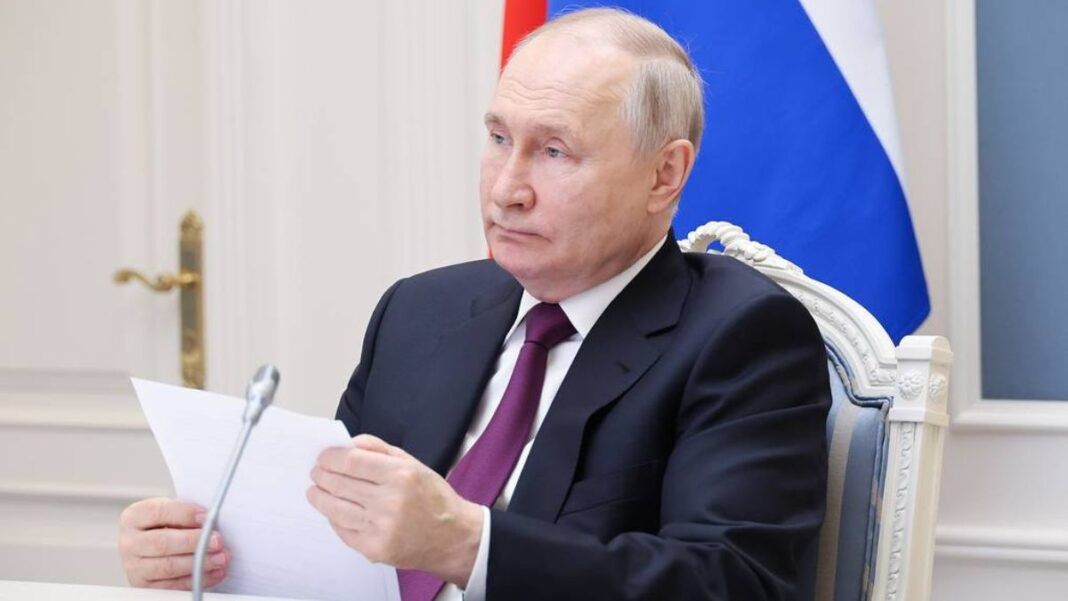 O presidente Vladimir Putin segura uma folha de papel diante do microfone