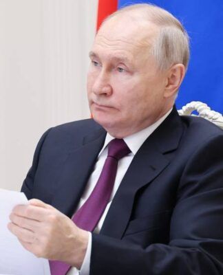 O presidente Vladimir Putin segura uma folha de papel diante do microfone