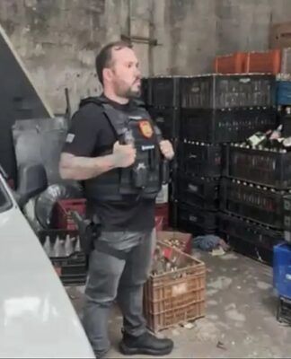 Policial participa de mandado de busca em depósito cheio de garrafas vazias