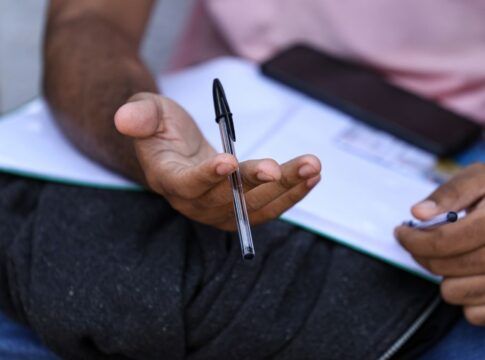 Candidato segura caneta e checa informações da prova depois do segundo dia do Enem no último domingo