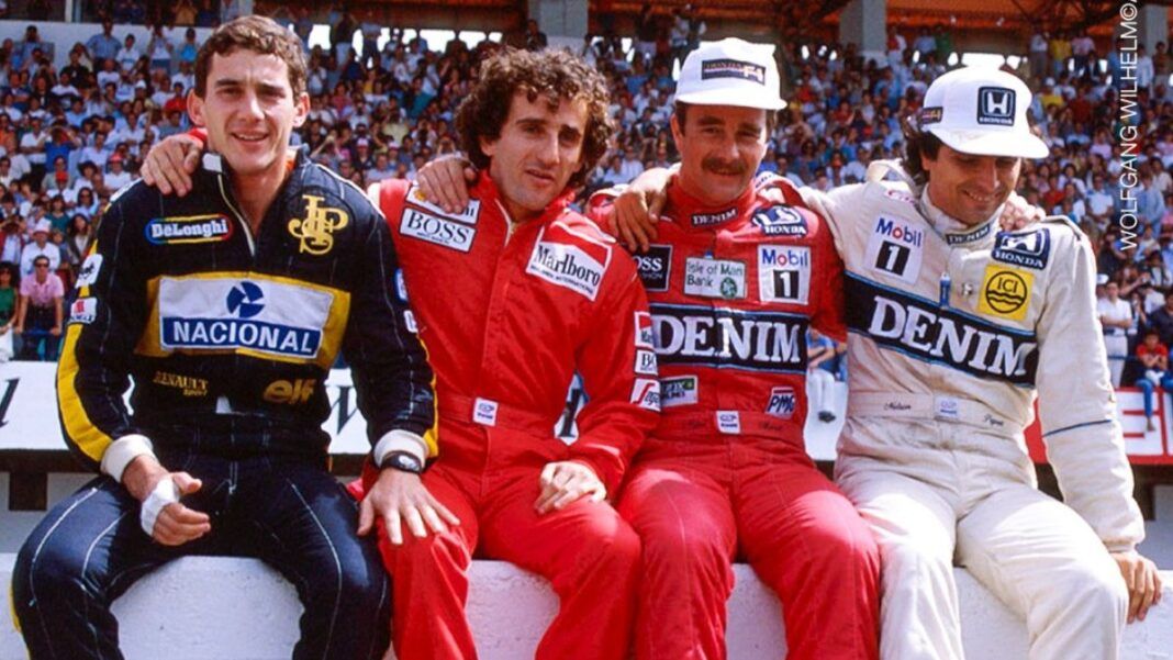 Ayrton Senna, Alain Prost, Nigel Mansell e Nelson Piquet estão sentados numa mureta com seus macacões durante um GP