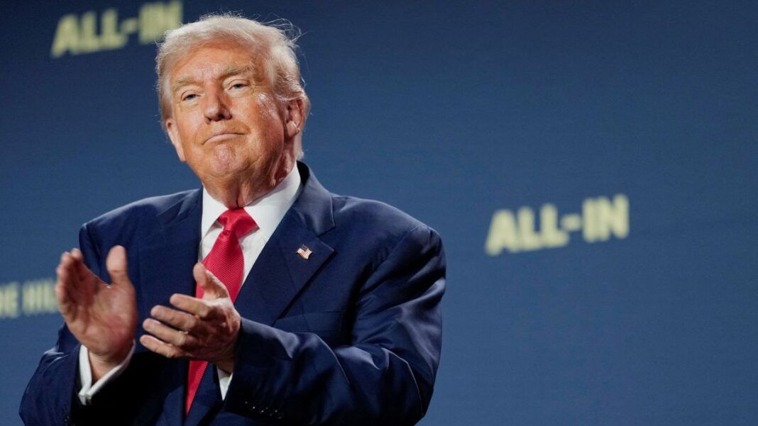 Trump aplaude com expressão de ironia à frente de um fundo azul