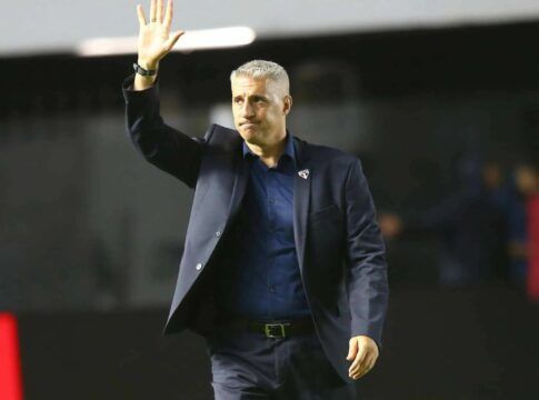 Crespo de terno escuro, acenando para torcida, do campo.