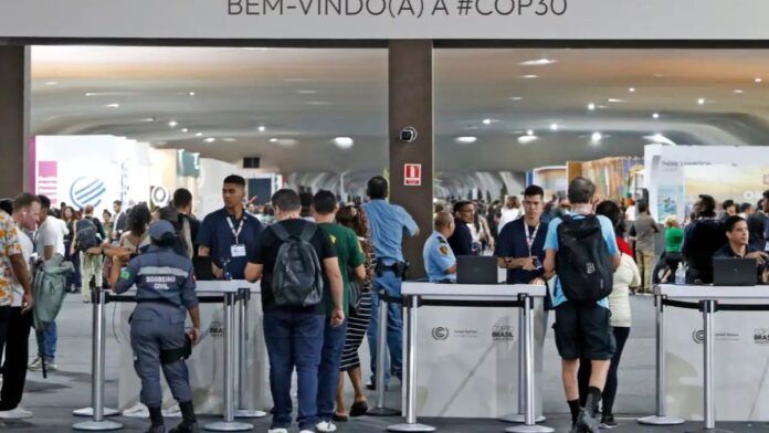 Multidão atravessando os portões de entrada da COP30
