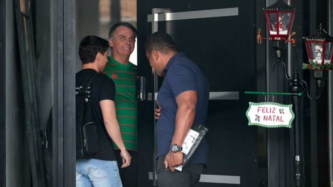 Jair Bolsonaro veste camisa verde na entrada de sua casa