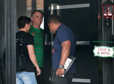Jair Bolsonaro veste camisa verde na entrada de sua casa