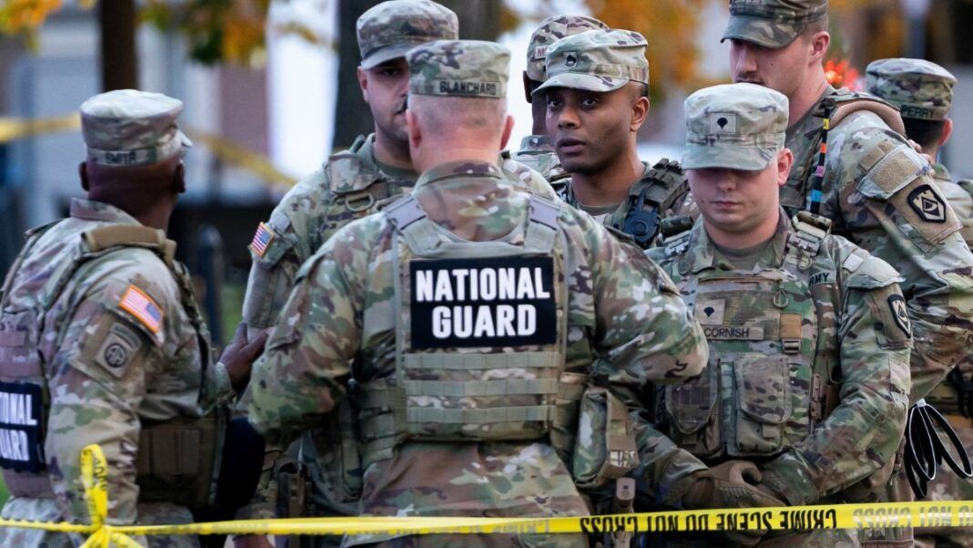 Soldados da Guarda Nacional reunidos atrás de uma linha policial