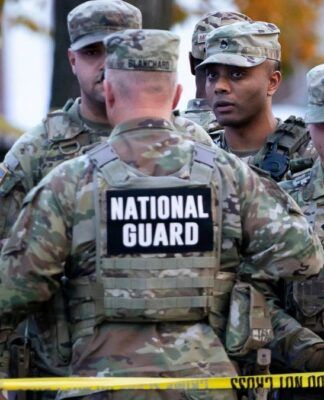 Soldados da Guarda Nacional reunidos atrás de uma linha policial