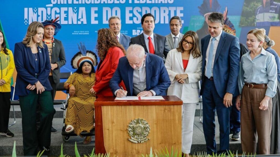 Lula assinando projeto de lei em palanque com ministros em volta
